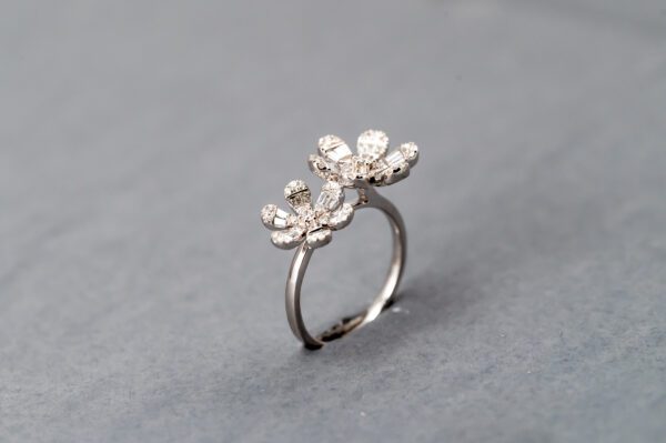 A silver ring with two flowers on it.