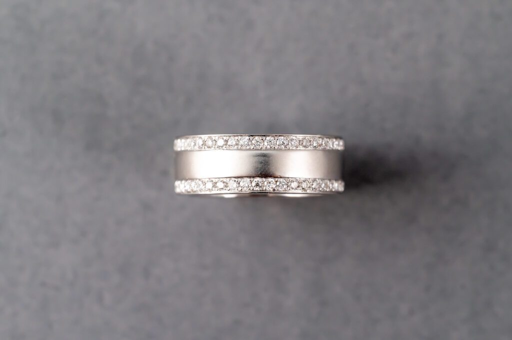 A silver ring with diamonds on top of it.