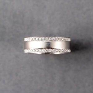 A silver ring with diamonds on top of it.
