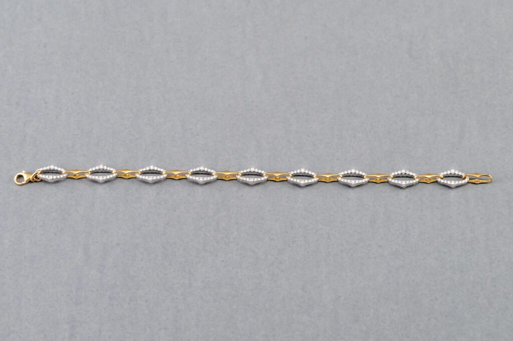A chain of gold and silver links on a gray background.