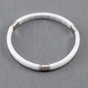 A white bracelet with silver accents on it.
