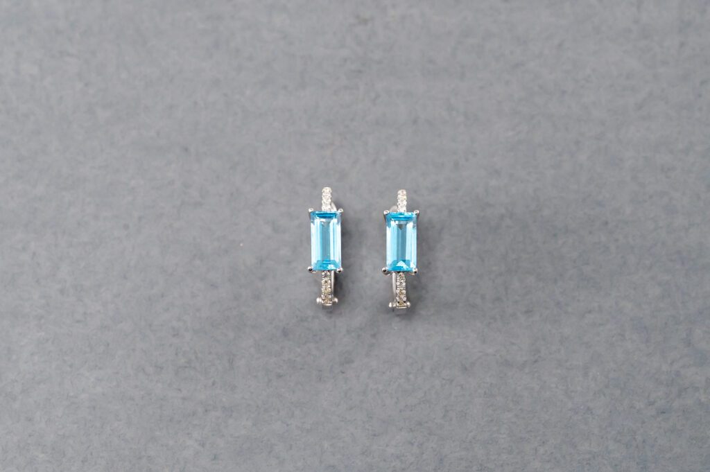 A pair of blue earrings sitting on top of a table.