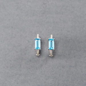 A pair of blue earrings sitting on top of a table.