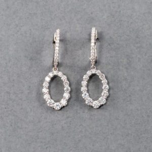 A pair of diamond earrings with a small oval shaped frame.