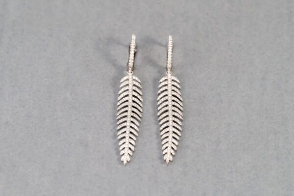 A pair of silver earrings with a leaf design.