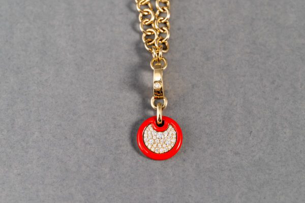 A red and gold chain with a small pendant.