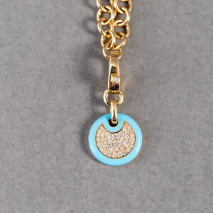 A gold chain with a blue charm on it.