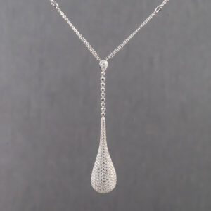 A silver necklace with a long chain and a drop shaped pendant.