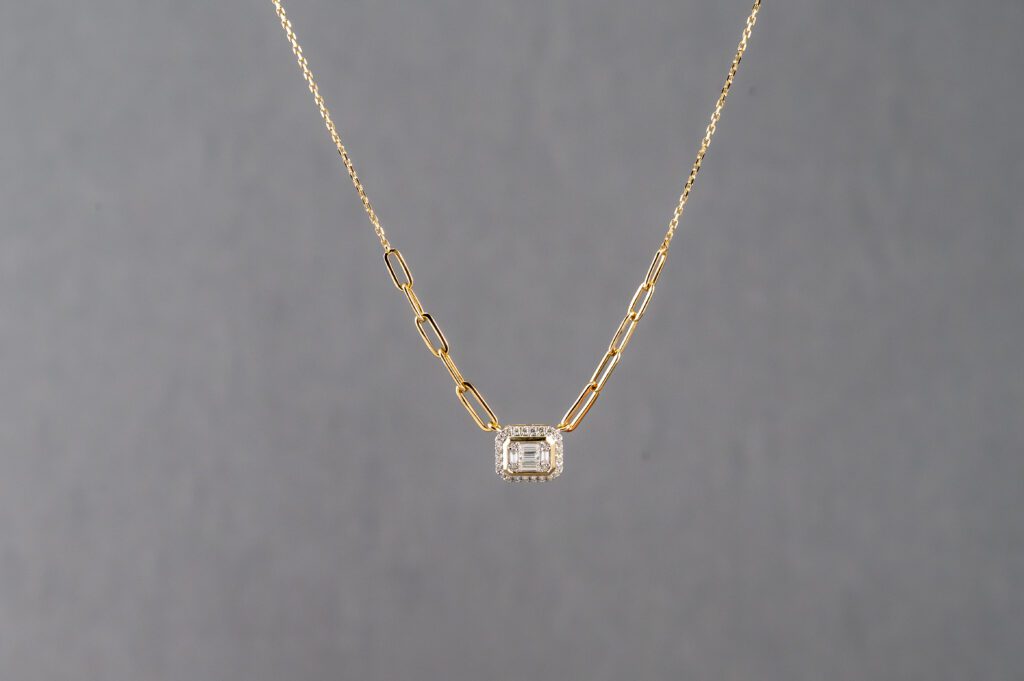 A gold chain with a diamond on it