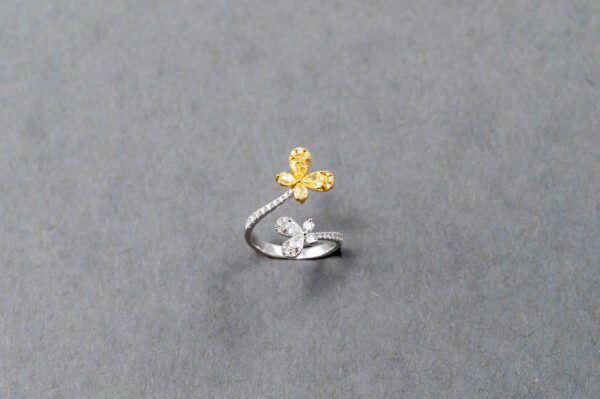 A silver ring with a yellow flower on it.