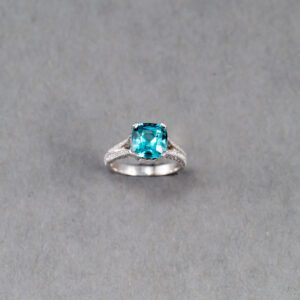 A blue stone is sitting on top of a silver ring.